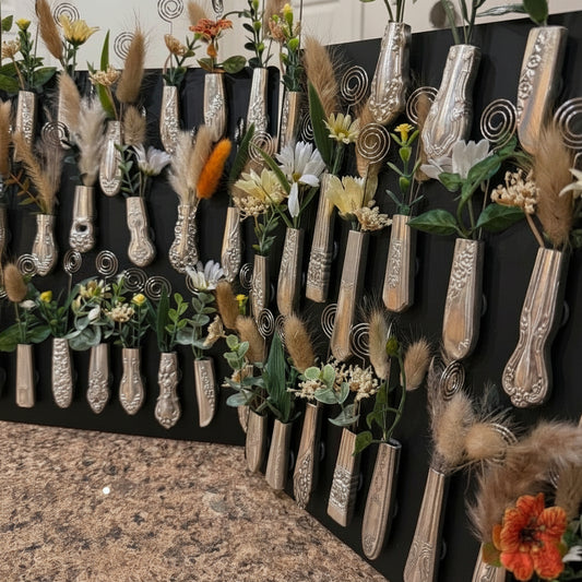 Decorative silverware knife handle magnets with floral arrangements and a photo pick on a black magnet background