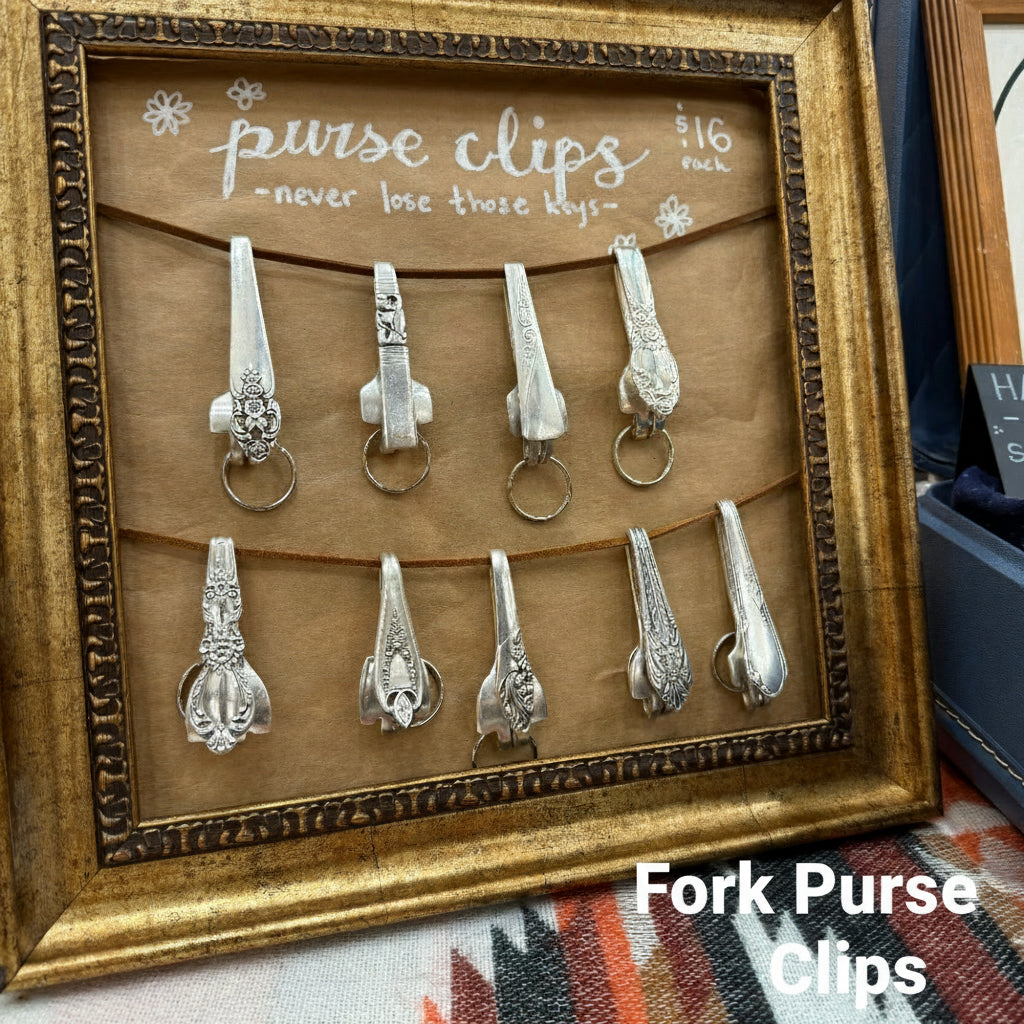 Set of silver purse clips in a decorative frame with text